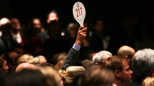 A man holds his hand up while bidding on a work of art inside the auction house Christie's during the Post-War and contemporary Art sale November 15, 2006 in New York City.