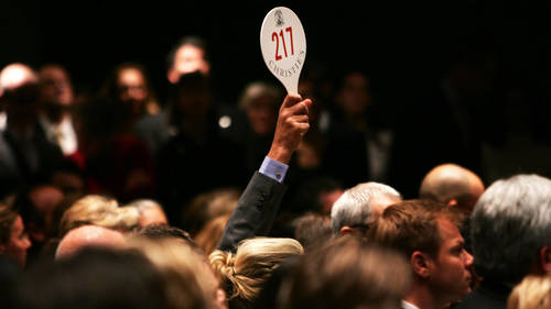 A man holds his hand up while bidding on a work of art inside the auction house Christie's during the Post-War and contemporary Art sale November 15, 2006 in New York City. 