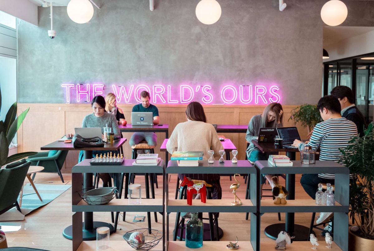 "The World's Ours" people in co-working space on laptops