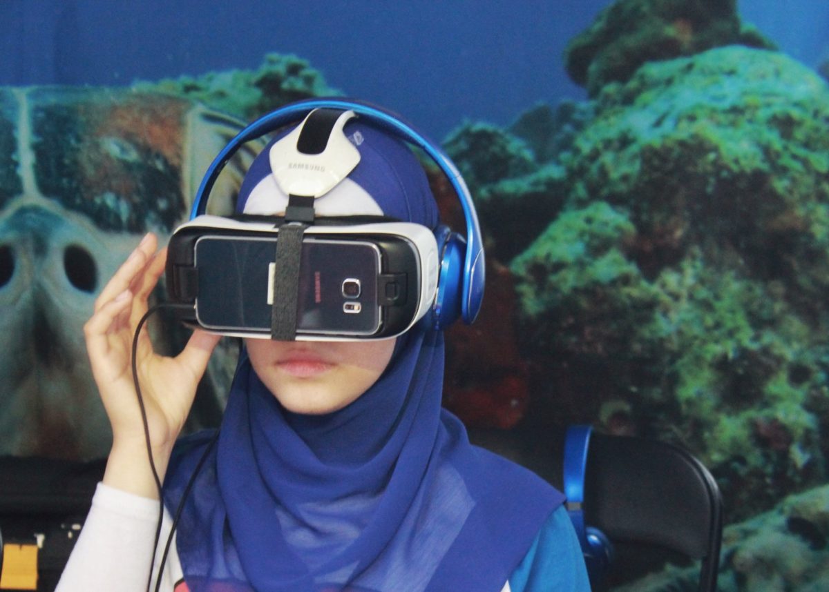 Young woman in a hijab using VR googles