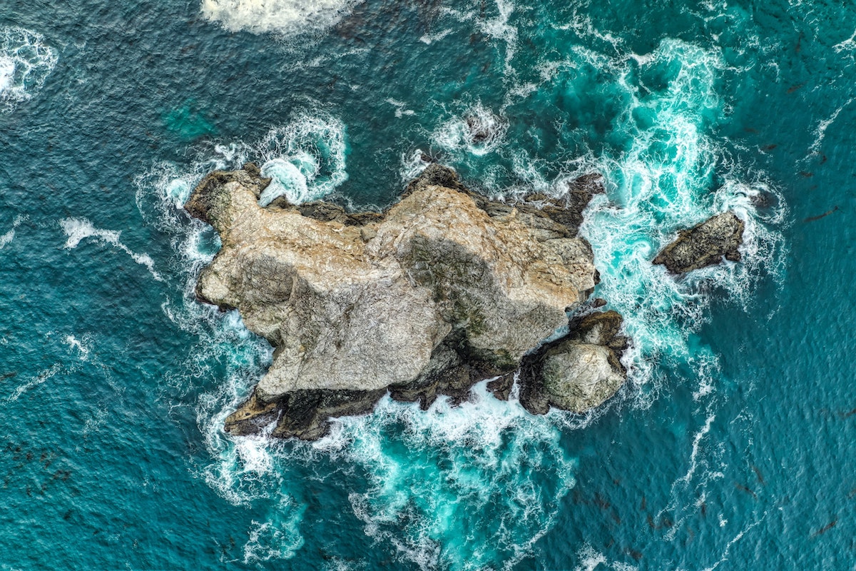 Aerial shot of a rock in the ocean in Big Sur